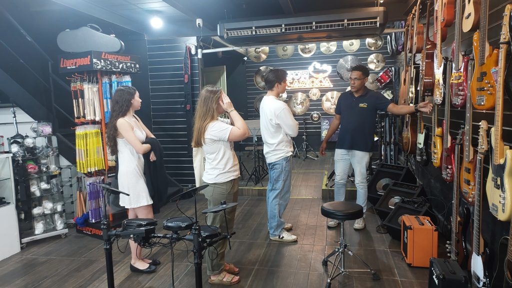 Estudiantes probando guitarras en una tienda local de música en Río